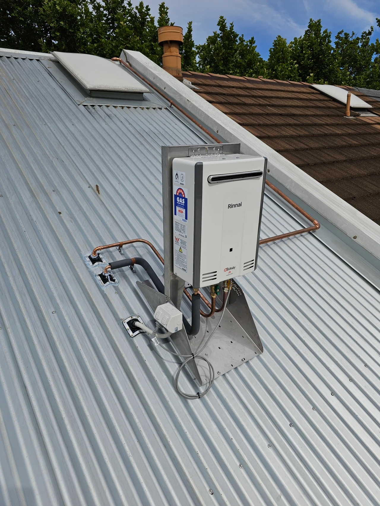 Rooftop continuous-flow hot-water unit with its original pipework and mounting