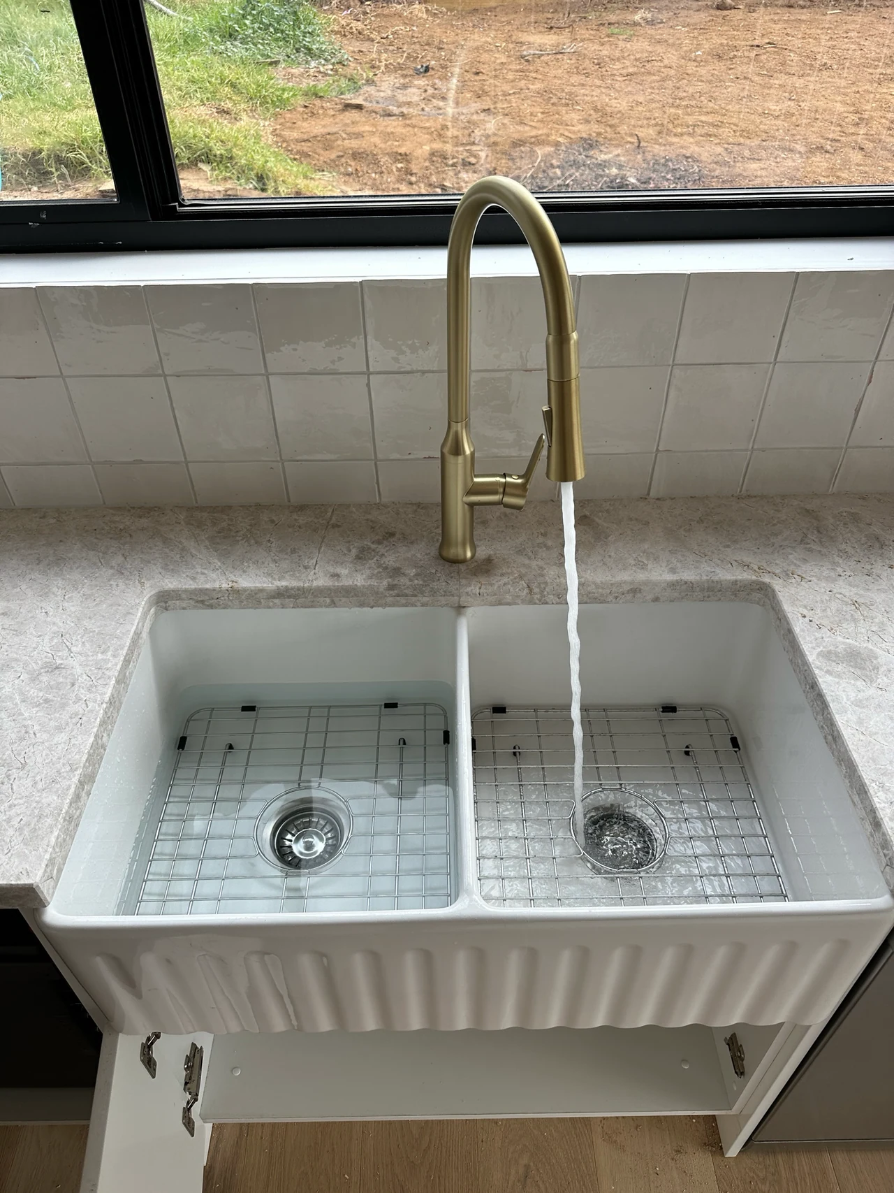 Brass kitchen mixer running above a double sink on a Flow-Rite job